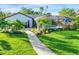 Inviting pool area with a screened enclosure, lush landscaping, and a stone walkway at 1899 Buccaneer Cir, Sarasota, FL 34231