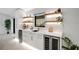 Modern wet bar with floating shelves, wine cooler, and herringbone tile backsplash at 1899 Buccaneer Cir, Sarasota, FL 34231