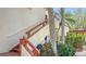 Exterior condo staircase with wooden railings and tropical plants at 304 Spring Lakes Blvd # 304, Bradenton, FL 34210
