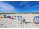 Beachfront scene with lounge chairs and beach umbrellas at 4360 Chatham Dr # 108, Longboat Key, FL 34228