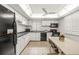 Bright kitchen features white cabinets, black appliances, and a tile floor at 4360 Chatham Dr # 108, Longboat Key, FL 34228