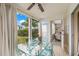 Bright sunroom features a glass-top dining table, seating area, and access to the outdoors at 4360 Chatham Dr # 108, Longboat Key, FL 34228