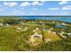Aerial view showcasing a waterfront property with surrounding houses and open space at 445 Horseshoe Loop Rd, Terra Ceia, FL 34250