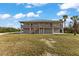 Two-story home with elevated deck and grassy yard at 445 Horseshoe Loop Rd, Terra Ceia, FL 34250
