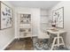 Home office features a standing desk, built-in shelving, and hardwood floors at 445 Horseshoe Loop Rd, Terra Ceia, FL 34250
