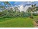 Landscaped backyard with lush tropical plants and grass at 4655 Tower Hill Ln # 2412, Sarasota, FL 34238