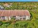 Ground level view of condo building with screened lanai and lush landscaping at 4655 Tower Hill Ln # 2412, Sarasota, FL 34238
