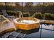 Octagonal hot tub with tiled surround, steps, and calming lights at 4964 Bella Terra Dr, Venice, FL 34293