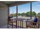 Screened porch with outdoor seating and view of tennis courts at 528 Forest Way, Longboat Key, FL 34228