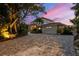 Home with a large driveway and beautiful landscaping at sunset at 585 Gunwale Ln, Longboat Key, FL 34228