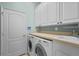 Laundry room with washer, dryer, cabinets, and countertop at 6207 Warbler Ln, Lakewood Ranch, FL 34202