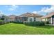Home with a spacious backyard, screened patio, and well-manicured lawn at 7615 Windward Cv, Lakewood Ranch, FL 34202