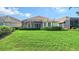 Home features a large grassy backyard with screened patio at 7615 Windward Cv, Lakewood Ranch, FL 34202