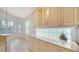 Bright kitchen boasts ample cabinetry and a lovely glass block window at 7615 Windward Cv, Lakewood Ranch, FL 34202