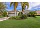 Single-story home with a light-colored exterior, attractive landscaping, and a two-car garage at 12240 Thornhill Ct, Lakewood Ranch, FL 34202