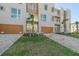Contemporary townhouses featuring wood-toned garage doors and landscaped yards at 1720 Alderman St, Sarasota, FL 34236