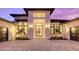 Modern home with a white stone facade, double garage doors, and palm trees at 19439 Beacon Park Pl, Bradenton, FL 34202
