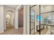Elegant hallway with arched doorways, wood floors, and glass-walled office at 19439 Beacon Park Pl, Bradenton, FL 34202