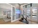 Home gym with Peloton bike, view of pool and lake, and access to the main bedroom at 19439 Beacon Park Pl, Bradenton, FL 34202
