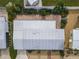 An aerial view of a home with a metal roof, brick patios, rock landscaping, and a white fence around the perimeter at 2107 Palma Sola Blvd # 84, Bradenton, FL 34209