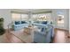 Bright living room featuring blue sofas, wood floors, and a neutral area rug for a cozy space at 2107 Palma Sola Blvd # 84, Bradenton, FL 34209