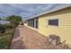 Outdoor patio with brick pavers, mature shrubs, and a yellow home exterior create a welcoming backyard at 2107 Palma Sola Blvd # 84, Bradenton, FL 34209