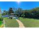 Expansive backyard with lush greenery, patio, and stone pathway, perfect for outdoor enjoyment at 220 Monet Dr, Nokomis, FL 34275