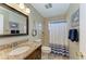 Bathroom with a granite vanity, shower, and nautical decor at 220 Monet Dr, Nokomis, FL 34275