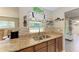 Kitchen featuring granite countertops, stainless steel sink, mosaic backsplash, and decorative coastal-themed accents at 220 Monet Dr, Nokomis, FL 34275