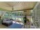 A screened patio with a ceiling fan, outdoor seating and colorful decor for a relaxing atmosphere at 220 Monet Dr, Nokomis, FL 34275