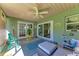 Relaxing sunroom with ceiling fan, vibrant accents, and a 