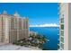 Aerial view of a modern highrise building with a pool and ample parking at 301 Quay Commons # 1111, Sarasota, FL 34236