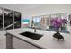 Modern kitchen island with a sink, white countertop and city views at 301 Quay Commons # 1111, Sarasota, FL 34236