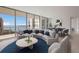 Bright living room with curved sofa, city views, and open floor plan at 301 Quay Commons # 1111, Sarasota, FL 34236