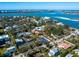 Aerial view showcasing the property's tennis court, proximity to water, and surrounding homes at 3460 Flamingo Ave, Sarasota, FL 34242