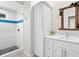 Bathroom with white vanity, walk-in shower with blue tile accents, and unique mirror at 3460 Flamingo Ave, Sarasota, FL 34242