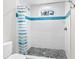 Modern bathroom with a walk-in shower featuring blue tile accents and pebble flooring at 3460 Flamingo Ave, Sarasota, FL 34242