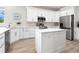 Bright, white kitchen featuring an island, stainless steel appliances, and ample counter space at 3460 Flamingo Ave, Sarasota, FL 34242