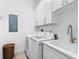 Laundry room with white cabinets, washer, dryer, and a utility sink at 3460 Flamingo Ave, Sarasota, FL 34242