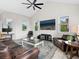 Living room with large TV, comfortable seating, and natural light from multiple windows at 3460 Flamingo Ave, Sarasota, FL 34242