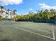 Private tennis court surrounded by lush greenery and palm trees at 3460 Flamingo Ave, Sarasota, FL 34242