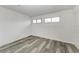Simple bedroom with wood-look floors and two windows at 4477 Sandner Dr, Sarasota, FL 34243