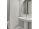 Small bathroom with pedestal sink and round mirror at 4672 Mondrian Ct, Sarasota, FL 34240