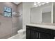 Bathroom with granite countertop, dark vanity, and glass shower at 4672 Mondrian Ct, Sarasota, FL 34240