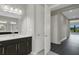 Modern bathroom with dark vanity, neutral color palette, and access to hallway at 4672 Mondrian Ct, Sarasota, FL 34240