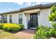 The front entrance is inviting, featuring a black door, manicured shrubs, and a brick walkway at 4705 Tortona Ct, Bradenton, FL 34211