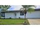 White single story home with black window frames and a landscaped lawn at 6593 Kenwood Dr, North Port, FL 34287