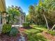 Landscaped backyard with a screened porch and lush greenery at 6642 Tailfeather Way, Bradenton, FL 34203