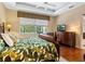 Main bedroom with leafy bedding and a large window at 6642 Tailfeather Way, Bradenton, FL 34203