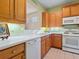 This kitchen features white appliances and wood cabinets at 6642 Tailfeather Way, Bradenton, FL 34203